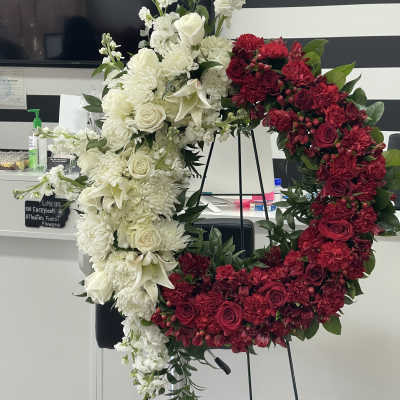 Large red and white floral wreath on a stand