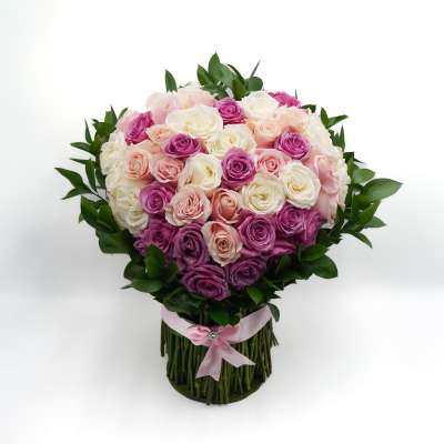 Bouquet of pink, white, and purple roses with a pink ribbon wrap