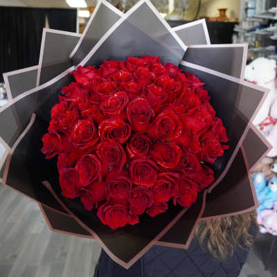 Large bouquet of red roses wrapped in black paper