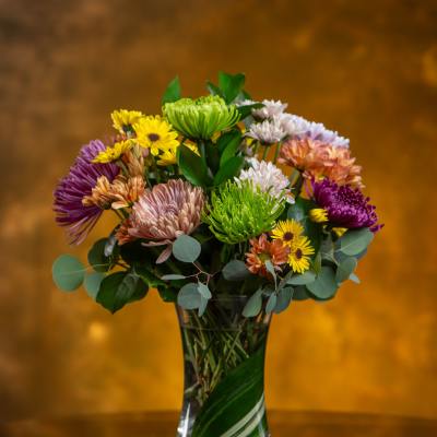 Mixed bouquet of colorful chrysanthemums in a clear glass vase