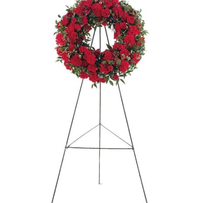 Red floral wreath on a metal easel stand