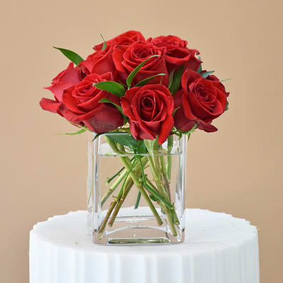 Red roses arranged in a clear glass vase