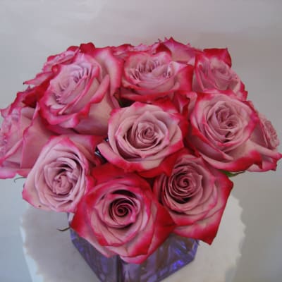 Bouquet of pink roses with red-edged petals in a glass vase