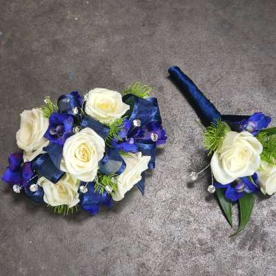 White roses with blue ribbon and accents, plus a matching boutonniere