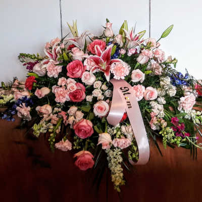 Large pink and white floral spray with a memorial ribbon