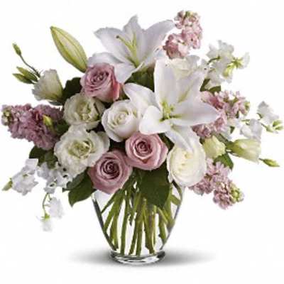 Bouquet of white lilies and pink roses in a clear glass vase