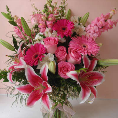 Pink bouquet with lilies, roses, and gerbera daisies in a glass vase