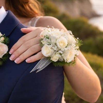 Bride and groom holding white rose corsages