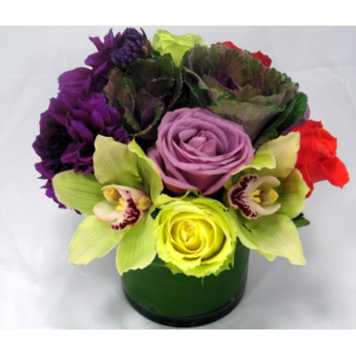 Colorful bouquet in a green vase with roses and orchids
