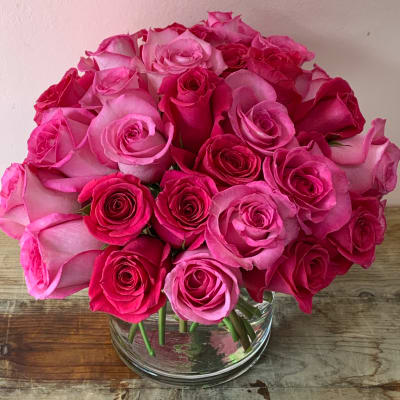 Pink and hot pink roses arranged in a clear glass vase