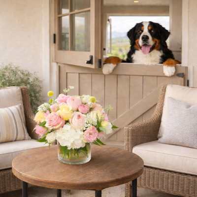Pastel bouquet in a clear glass vase on a patio table