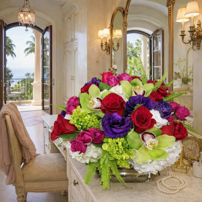 Large bouquet of red, pink, purple, white, and green flowers on a table
