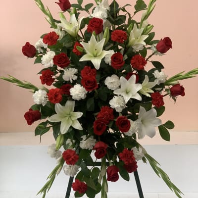 Standing floral spray with red roses, white lilies, and carnations