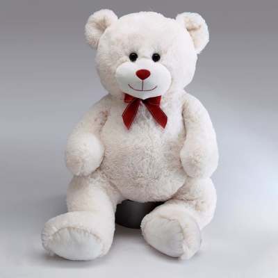 White teddy bear with a red bow sitting on a gray background