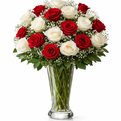 Red and white roses arranged in a clear glass vase