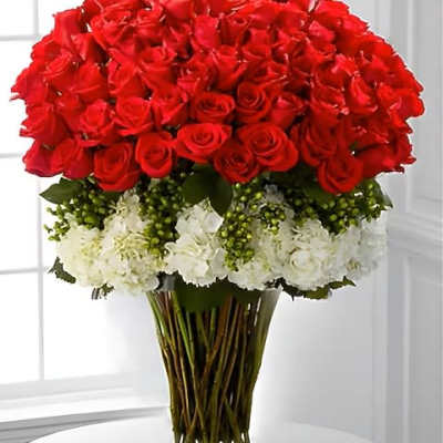 Large bouquet of red roses with white flowers in a clear glass vase