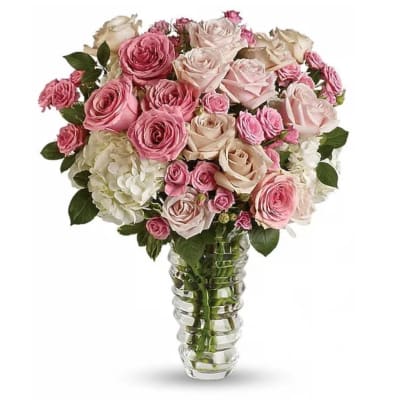 Pink and cream roses arranged in a clear glass vase
