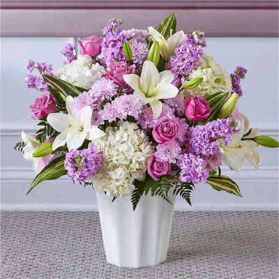 Lavender and white bouquet with lilies, roses, hydrangeas and mums in a white vase