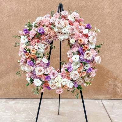 Pastel floral wreath on a black stand