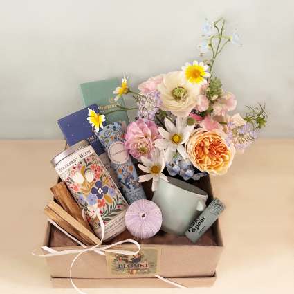 Gift box with pastel flowers, tea tins, and a mug