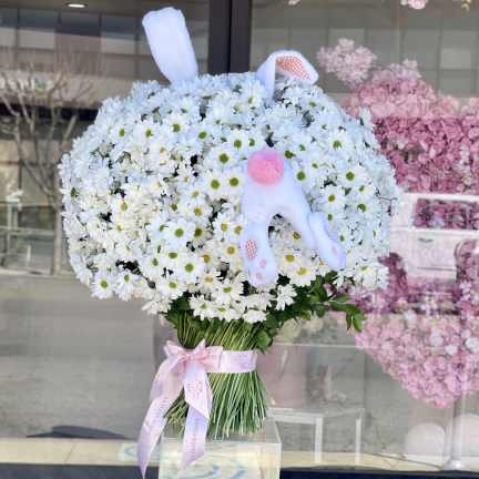 Bouquet of white daisies with a pink plush bunny