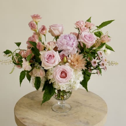 Pink and peach mixed flower arrangement in a clear glass vase