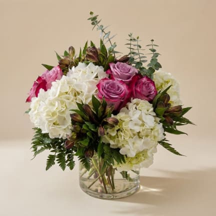 Pink roses and white hydrangeas in a clear glass vase