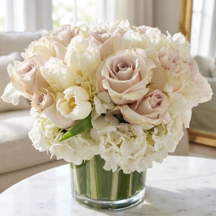 Blush roses and white hydrangeas in a clear glass vase