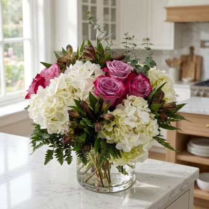 Bouquet of pink roses and white hydrangeas in a clear glass vase