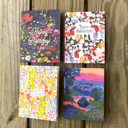 Set of four floral and scenic greeting cards with birthday, anniversary, and thinking of you messages on wood.