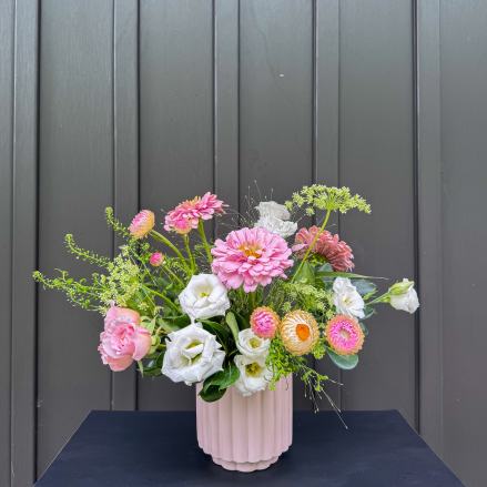 Pink and white mixed flower arrangement in a ribbed blush vase
