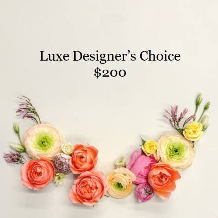 Flat lay of peach, pink, and yellow flowers styled in a crescent beneath pricing text