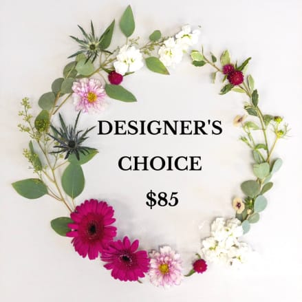 Flat lay wreath of mixed pink, white, and green flowers encircling text reading Designer's Choice $85