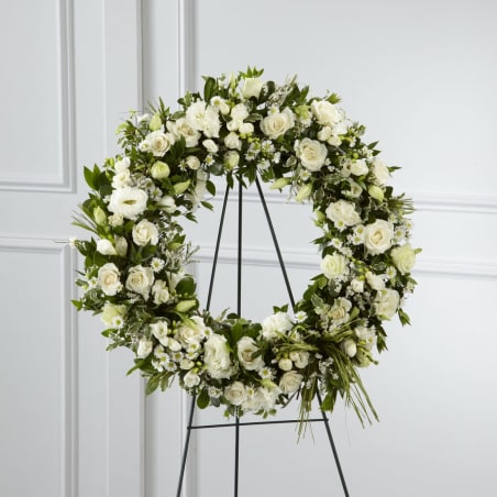 White floral wreath on a black stand