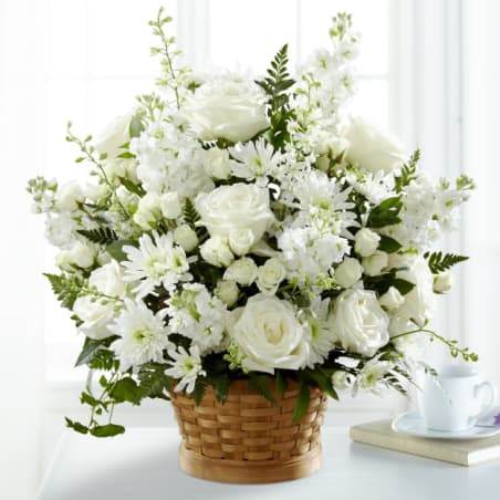 White roses and daisies arranged in a woven basket