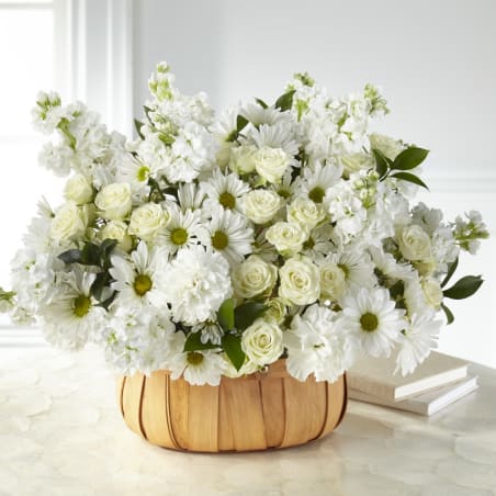 White roses and daisies in a woven basket