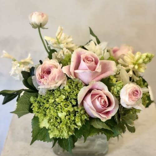 Pink roses and green hydrangeas in a glass vase