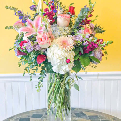Mixed bouquet in a clear glass vase with pink, white, and purple flowers