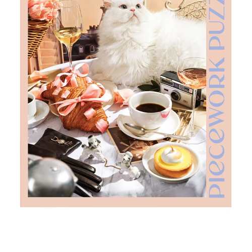 Jigsaw puzzle box featuring a white cat on a Parisian café table with pastries, coffee, wine, and the Eiffel Tower.