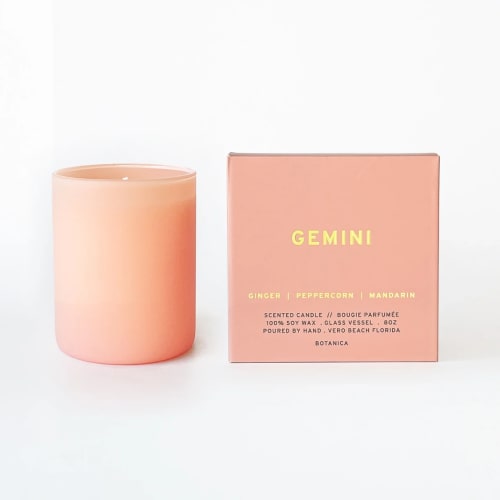 Peach scented candle in a glass vessel beside its matching box