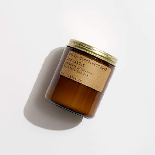 Amber glass candle jar with a gold lid and paper label
