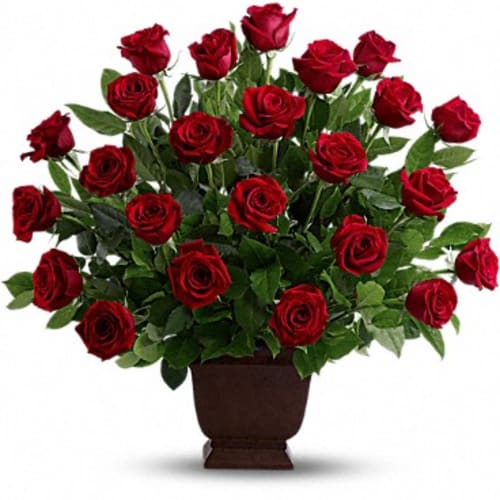 Red roses arranged in a brown urn vase