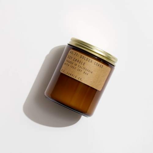 Amber soy candle in a glass jar with a gold lid and paper label