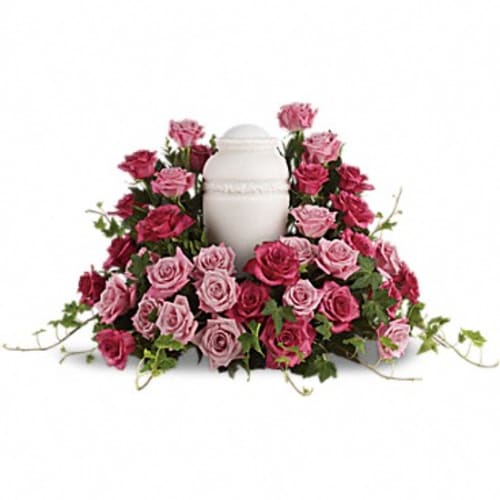 Pink and red roses arranged around a white urn