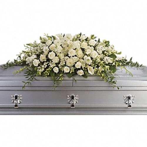 White floral casket spray on a gray casket