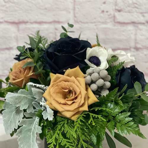 Bouquet of dark and peach roses with white anemones in a black vase