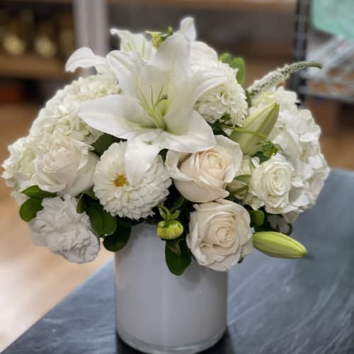 White lilies and roses arranged in a gray vase