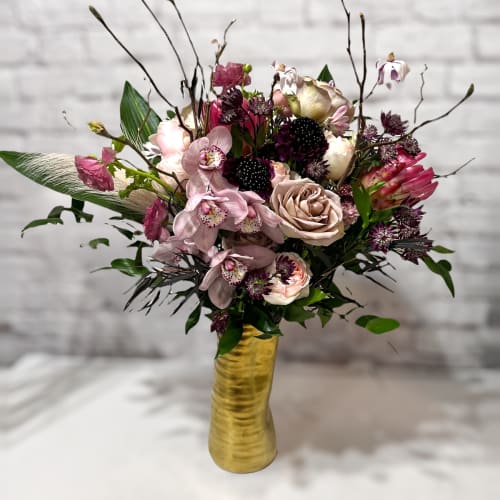 Mixed pink and cream floral arrangement in a gold vase