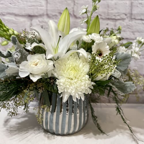 White floral arrangement in a striped ceramic vase