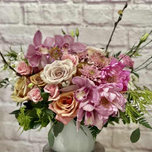 Pink and peach mixed flower arrangement in a white vase